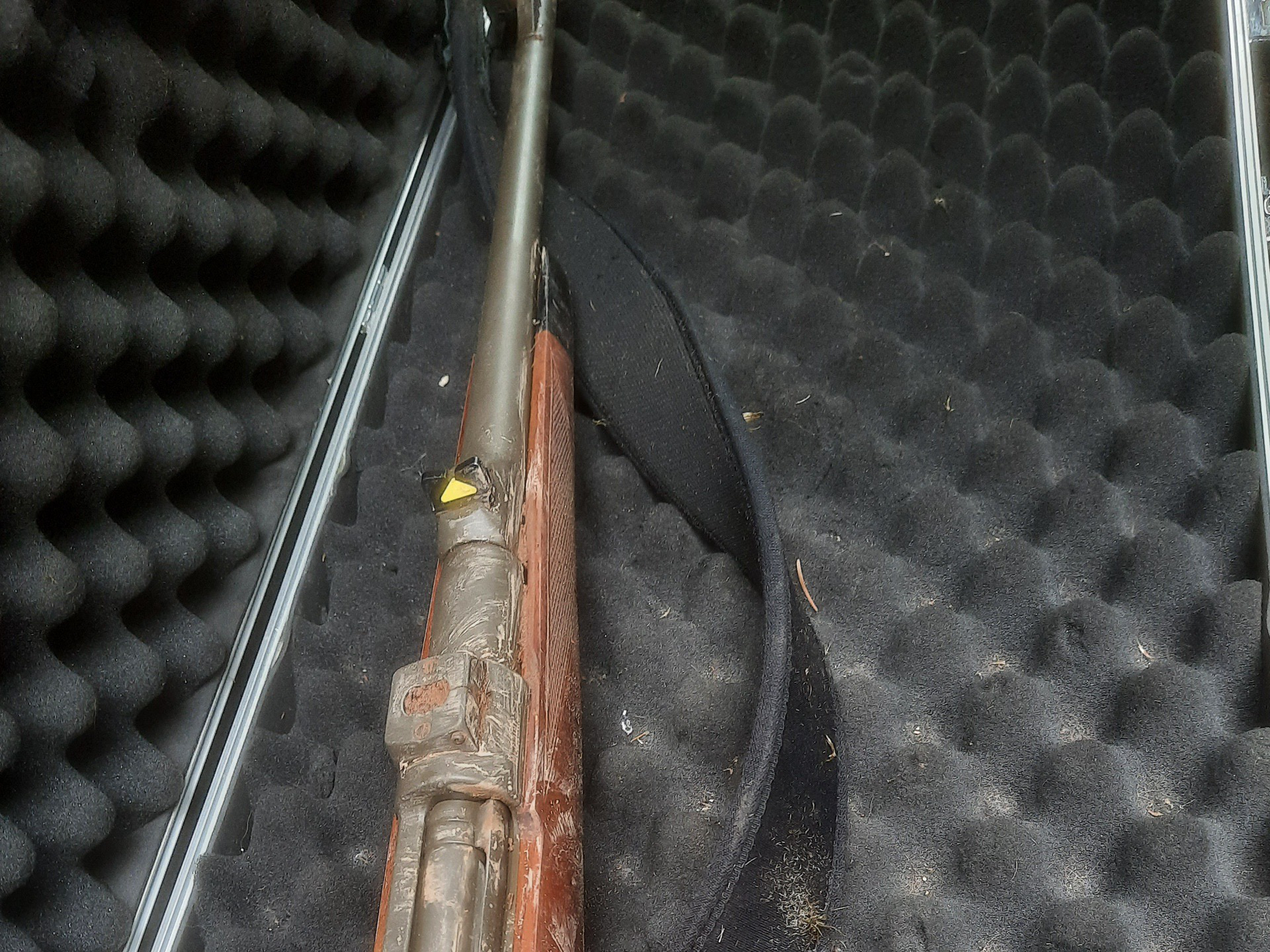 Ein Gewehr liegt in einem gepolsterten Koffer mit schwarzem Schaumstoff.